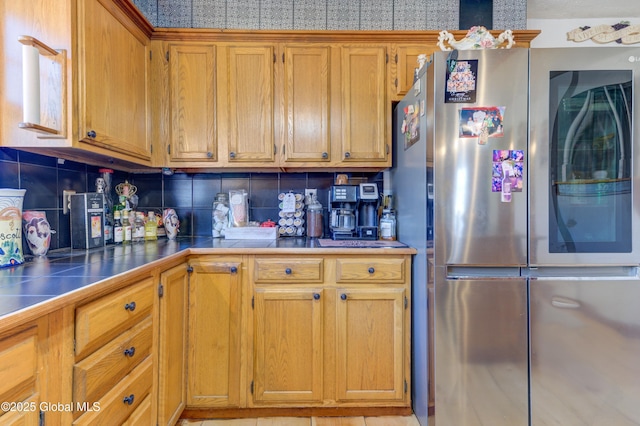 kitchen featuring brown cabinetry, decorative backsplash, smart refrigerator, and tile counters