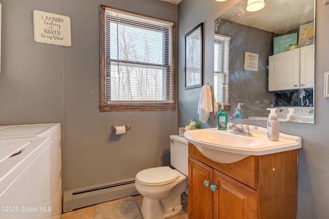 bathroom with a baseboard heating unit, toilet, washer and dryer, and vanity