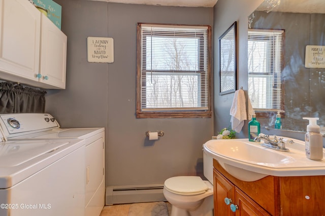 bathroom featuring washer and dryer, a baseboard heating unit, toilet, and vanity