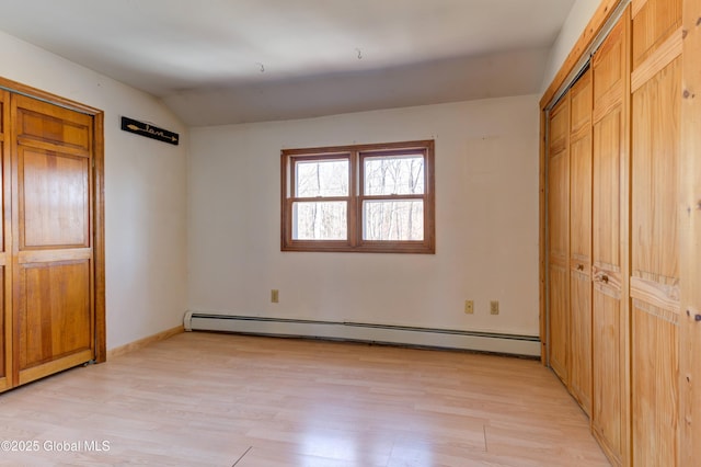 unfurnished bedroom featuring lofted ceiling, light wood-style flooring, baseboards, and baseboard heating