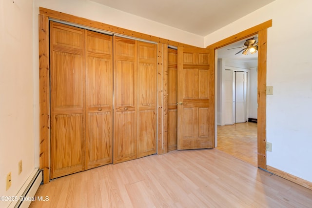 unfurnished bedroom with a baseboard radiator, baseboards, and light wood-style floors