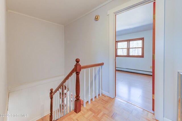 hallway featuring an upstairs landing, ornamental molding, wainscoting, and a baseboard radiator