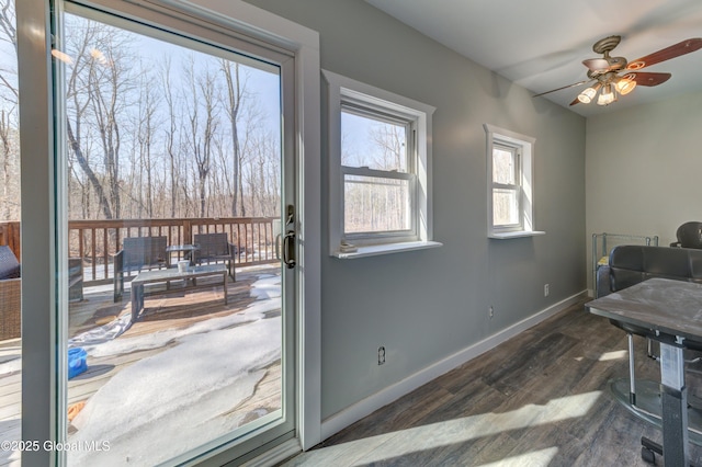 interior space featuring a ceiling fan, baseboards, and dark wood-style flooring