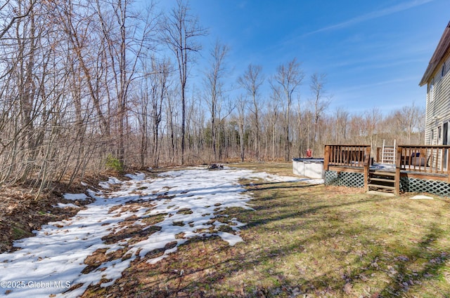 yard covered in snow with a wooden deck