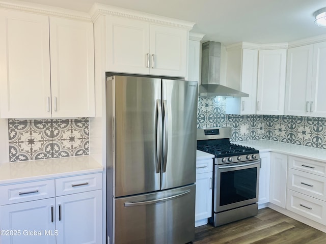 kitchen featuring light countertops, white cabinets, appliances with stainless steel finishes, wall chimney exhaust hood, and tasteful backsplash