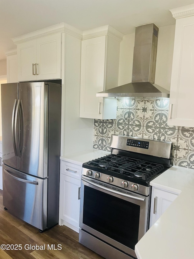 kitchen featuring dark wood finished floors, white cabinetry, appliances with stainless steel finishes, wall chimney exhaust hood, and light countertops