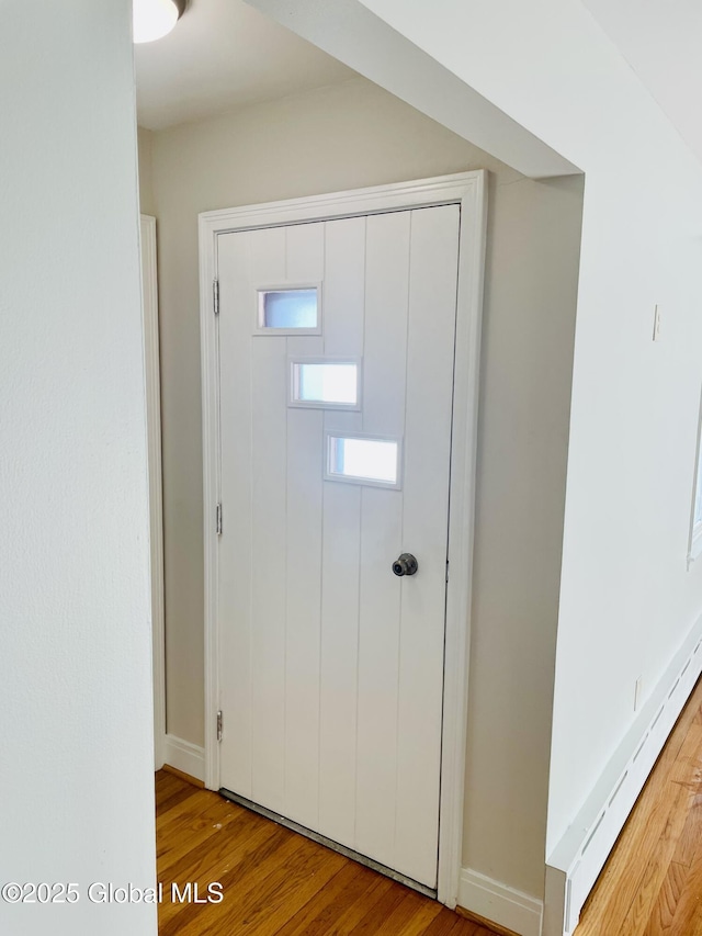 foyer featuring wood finished floors and baseboard heating