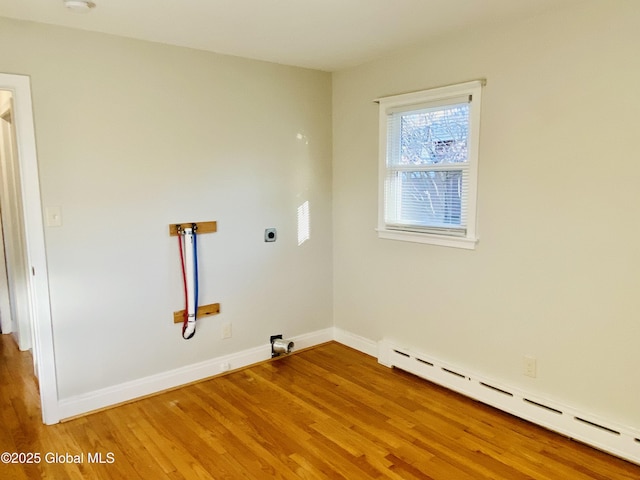 washroom with laundry area, baseboards, light wood-style floors, and a baseboard radiator