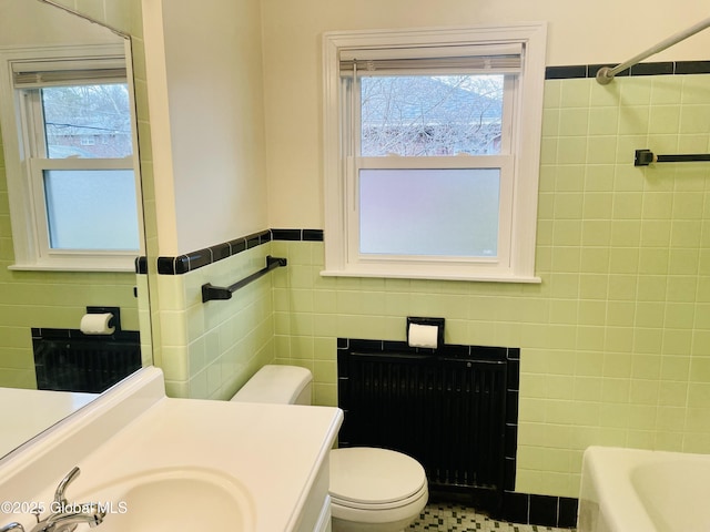 bathroom featuring walk in shower, toilet, vanity, a bath, and tile walls