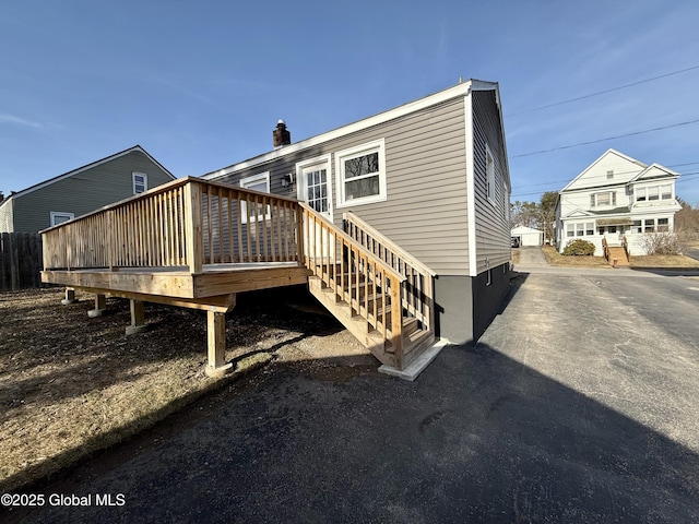 back of house featuring a deck and a chimney