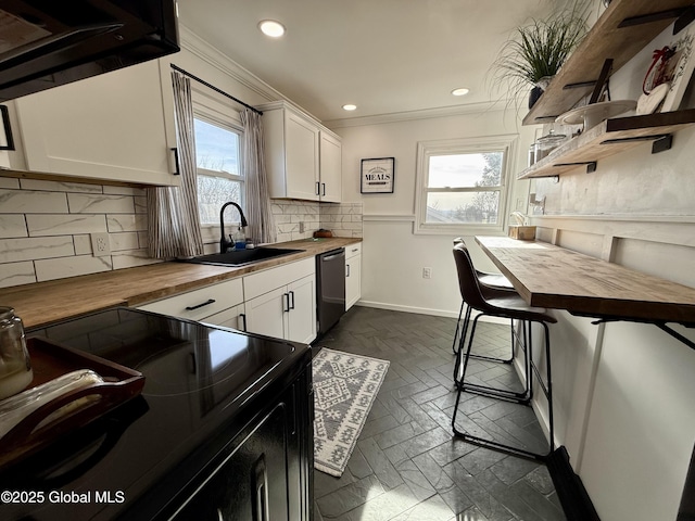 kitchen featuring a sink, black range with electric stovetop, butcher block counters, decorative backsplash, and stainless steel dishwasher