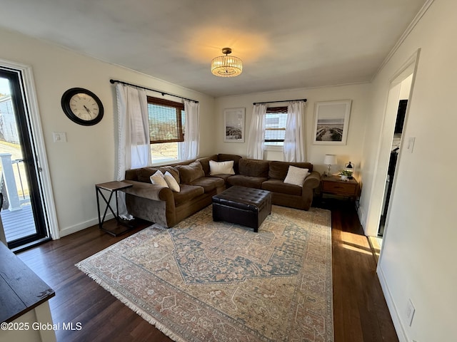 living room with a chandelier, baseboards, and dark wood finished floors