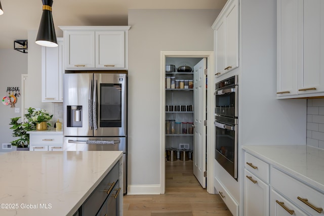 kitchen featuring decorative backsplash, white cabinets, and light wood-style floors