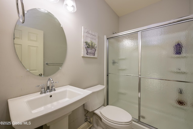 full bath featuring a shower stall, toilet, and a sink