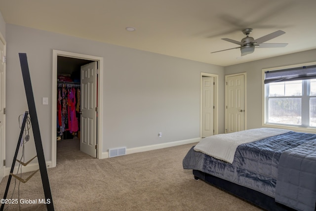 bedroom featuring a spacious closet, visible vents, carpet flooring, and baseboards