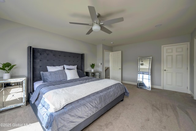 bedroom with a ceiling fan, baseboards, and carpet floors