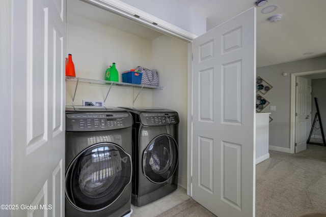 clothes washing area featuring washer and clothes dryer, laundry area, baseboards, and carpet