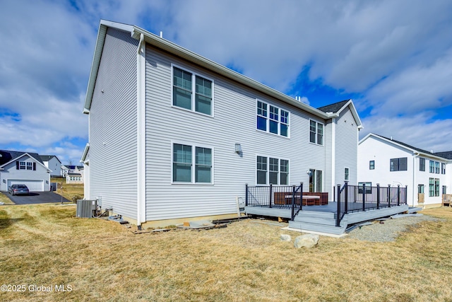 back of house featuring a deck, a yard, and central AC unit