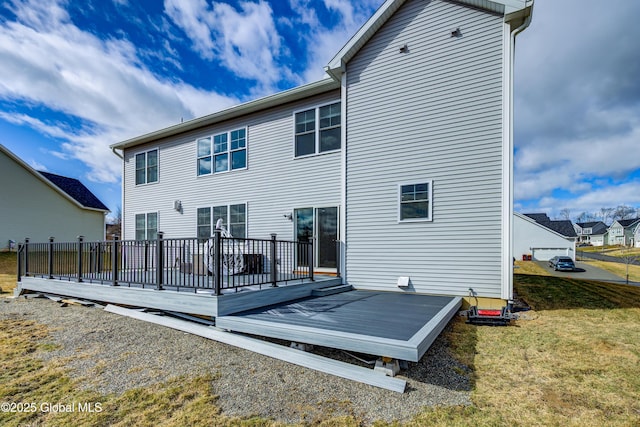 rear view of house featuring a yard and a deck