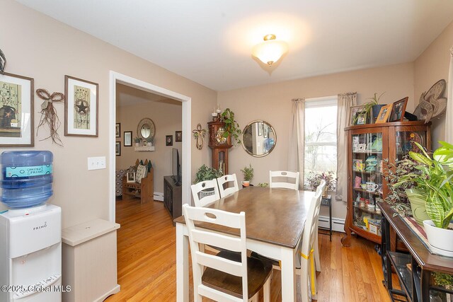 dining area featuring light wood-type flooring and baseboard heating