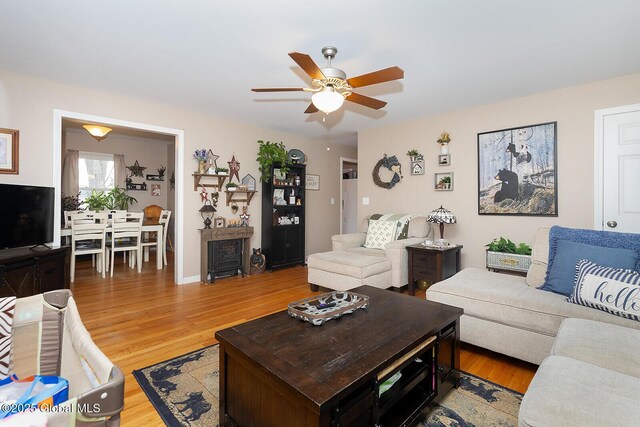 living room with a ceiling fan and light wood-style floors