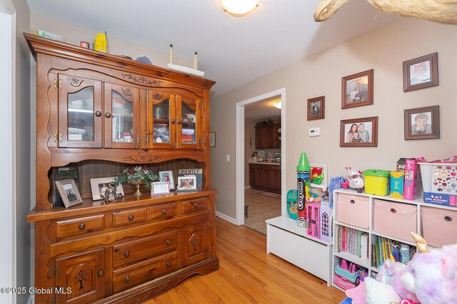 game room with light wood-type flooring and baseboards