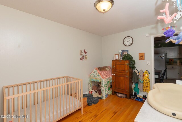 bedroom featuring freestanding refrigerator and wood finished floors