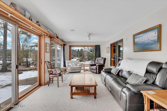 carpeted living area with ceiling fan