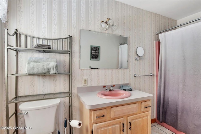 bathroom with wallpapered walls, tile patterned floors, toilet, and vanity