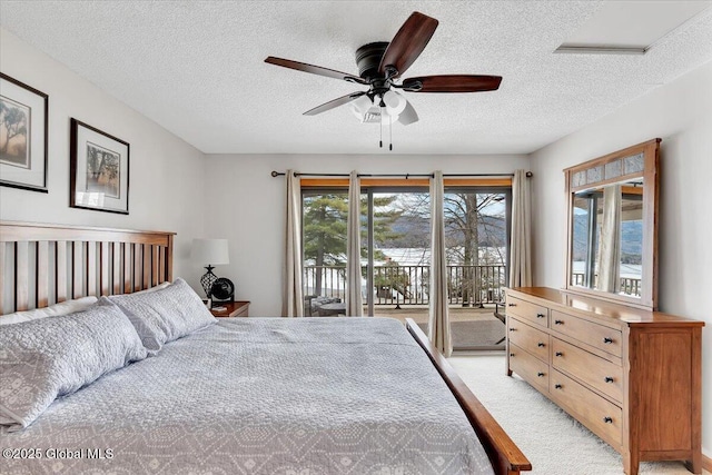 bedroom with ceiling fan, light carpet, a textured ceiling, and access to exterior