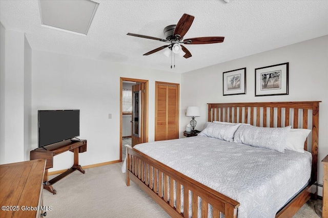 bedroom with baseboards, ceiling fan, a closet, a textured ceiling, and light carpet