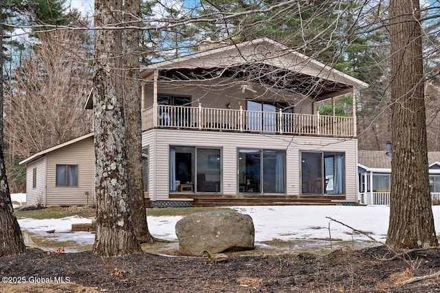 rear view of house featuring entry steps and a balcony