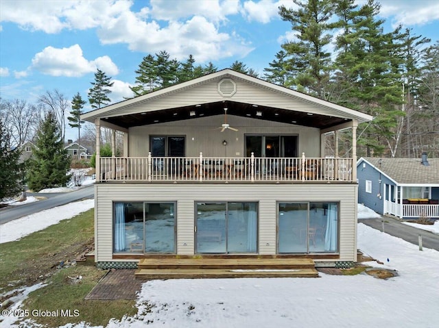 view of front of home with entry steps, a ceiling fan, and a balcony