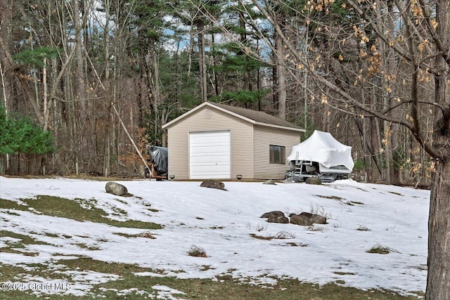 snow covered garage featuring a detached garage