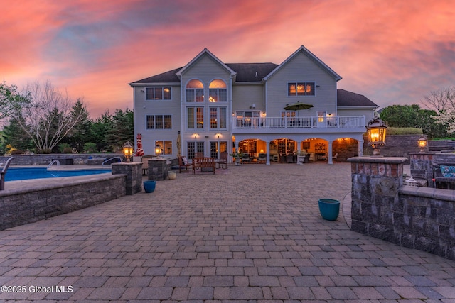 1014 Catherines Woods Dr, Niskayuna, NY 12309 - back of property with a fire pit, an outdoor pool, a patio area, and a balcony