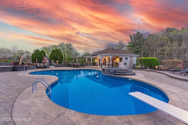 1014 Catherines Woods Dr, Niskayuna, NY 12309 - pool at dusk with a patio area, fence, a diving board, a jacuzzi, and an outdoor structure