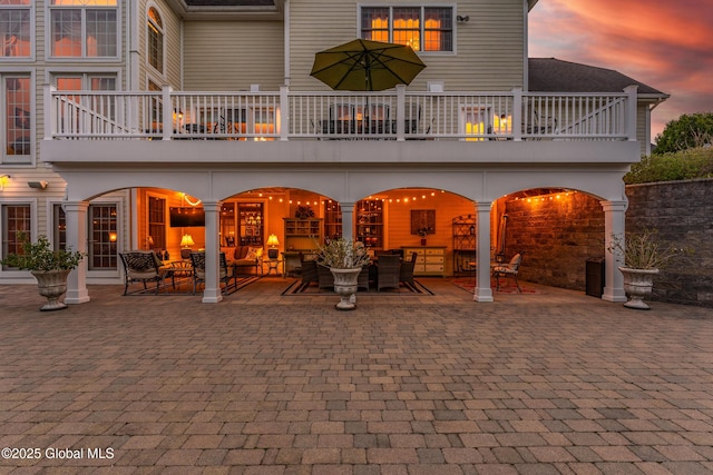 1014 Catherines Woods Dr, Niskayuna, NY 12309 - back of property at dusk with a balcony, an outdoor hangout area, and a patio