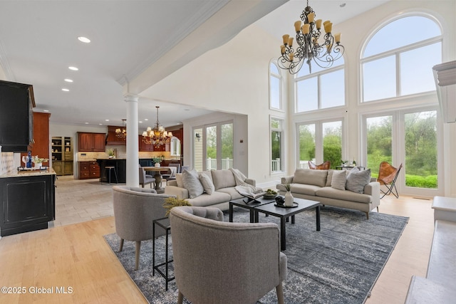 1014 Catherines Woods Dr, Niskayuna, NY 12309 - living room with a chandelier, recessed lighting, crown molding, light wood-style flooring, and ornate columns