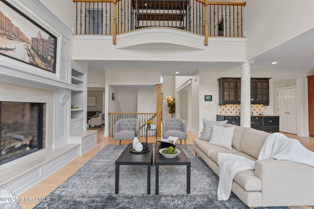 1014 Catherines Woods Dr, Niskayuna, NY 12309 - living area with ornate columns, light wood-type flooring, a towering ceiling, built in features, and recessed lighting
