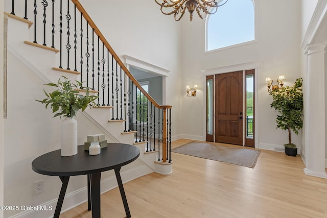 1014 Catherines Woods Dr, Niskayuna, NY 12309 - foyer with a chandelier, wood finished floors, a towering ceiling, baseboards, and stairway