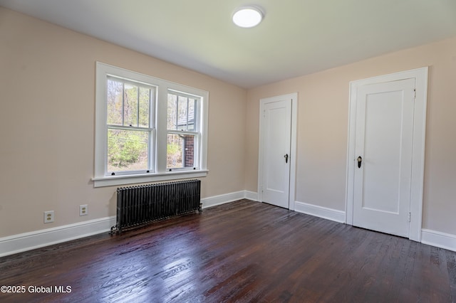 unfurnished bedroom with radiator, baseboards, and dark wood-style flooring