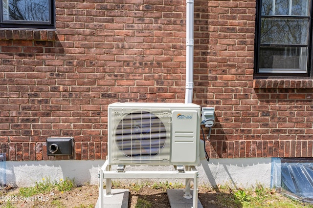 exterior details featuring brick siding and ac unit