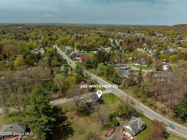 drone / aerial view featuring a wooded view