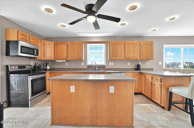 346 State Route 197, Fort Edward, NY 12828 - kitchen featuring a sink, ceiling fan, a peninsula, a kitchen island, and appliances with stainless steel finishes