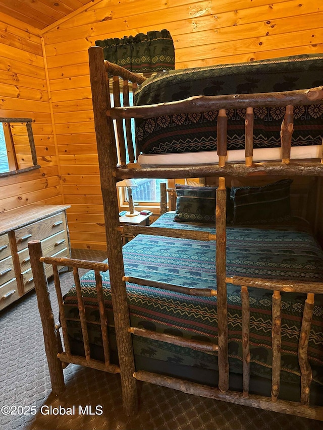 carpeted bedroom featuring wood walls and lofted ceiling
