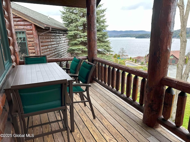 wooden deck with outdoor dining space and a water view