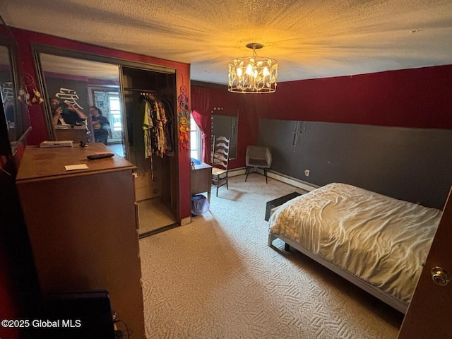 bedroom featuring a closet, carpet floors, a textured ceiling, and a chandelier