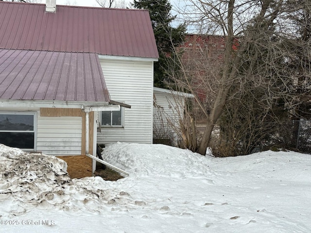 snow covered property featuring metal roof