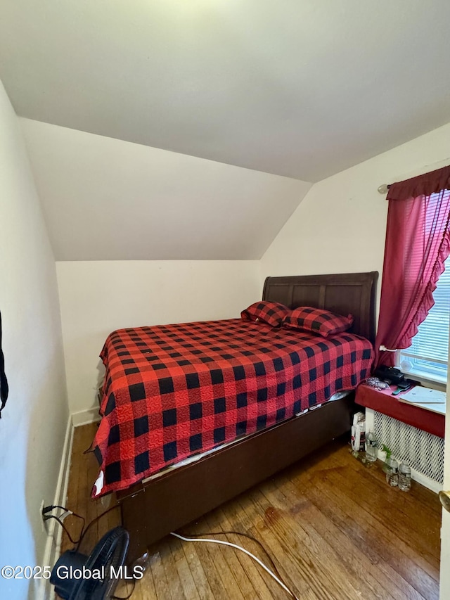 bedroom with lofted ceiling and wood-type flooring