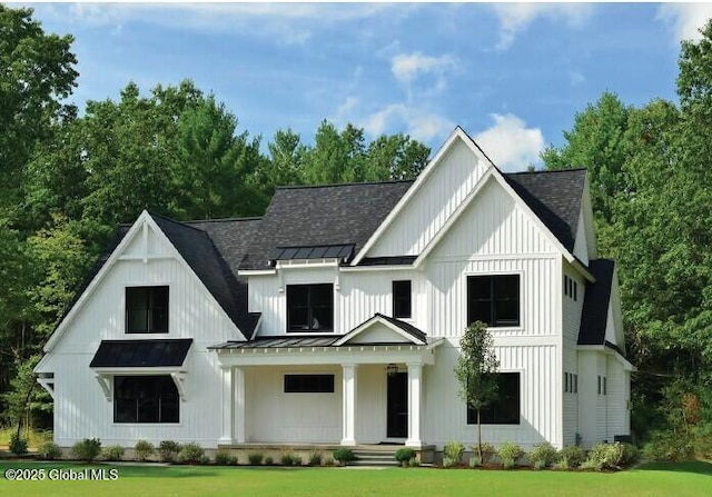 modern farmhouse with board and batten siding, a shingled roof, a standing seam roof, and metal roof